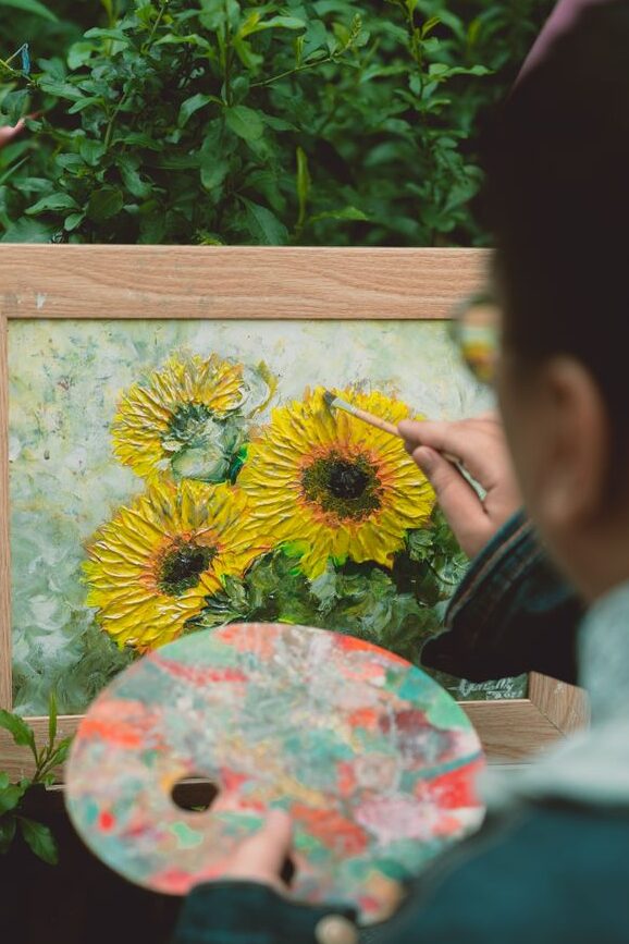 Home a man painting a sunflower on a canvas